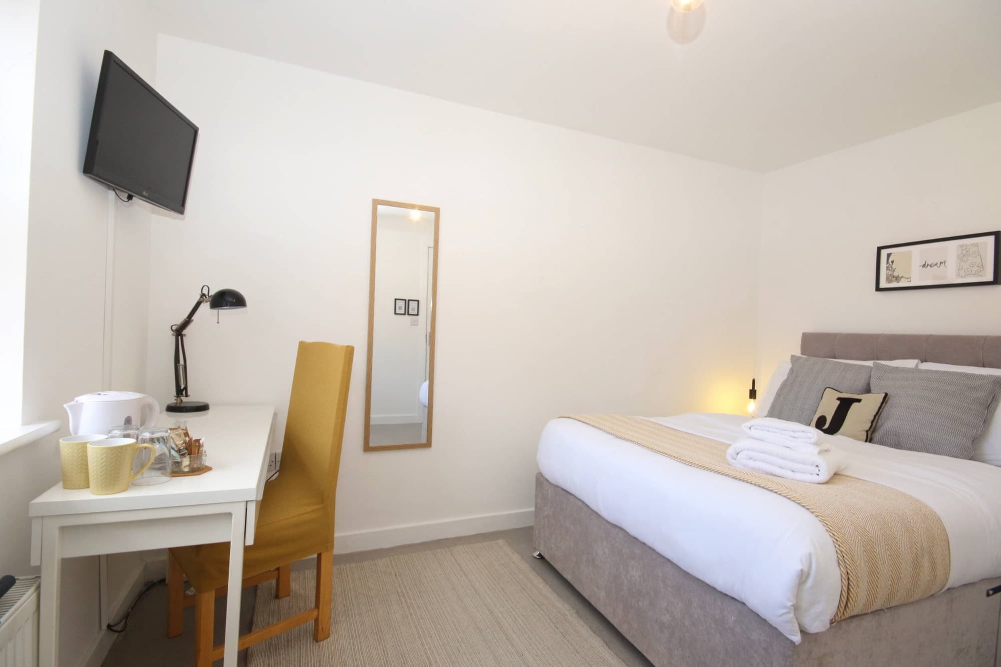 Bright double bedroom with soft furnishings and warm lighting in a Nottinghamshire short-let