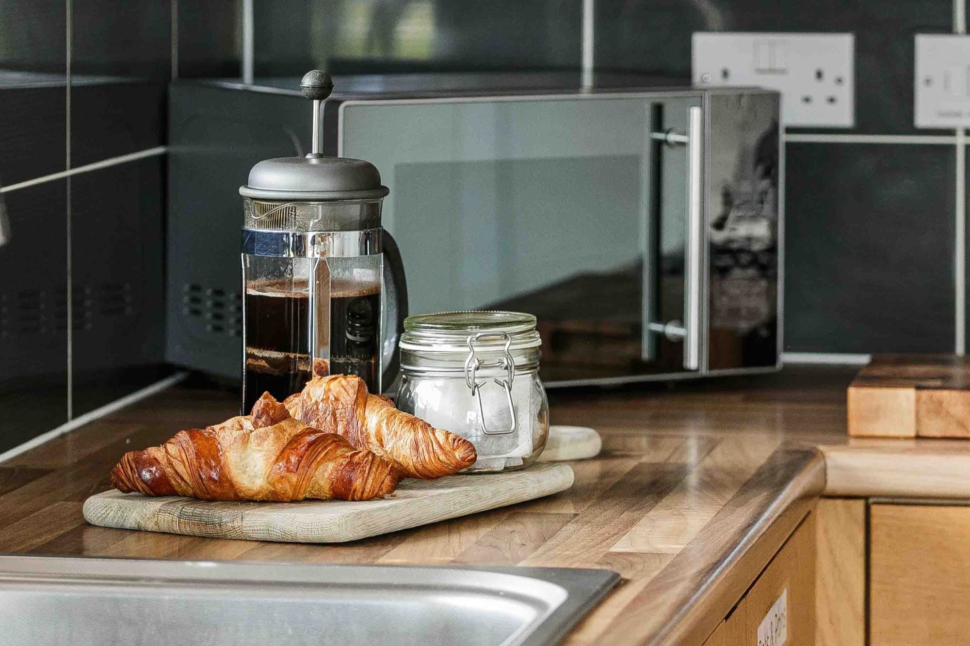 Kitchen worktop styled with a cafetière and croissants in a professionally managed Airbnb