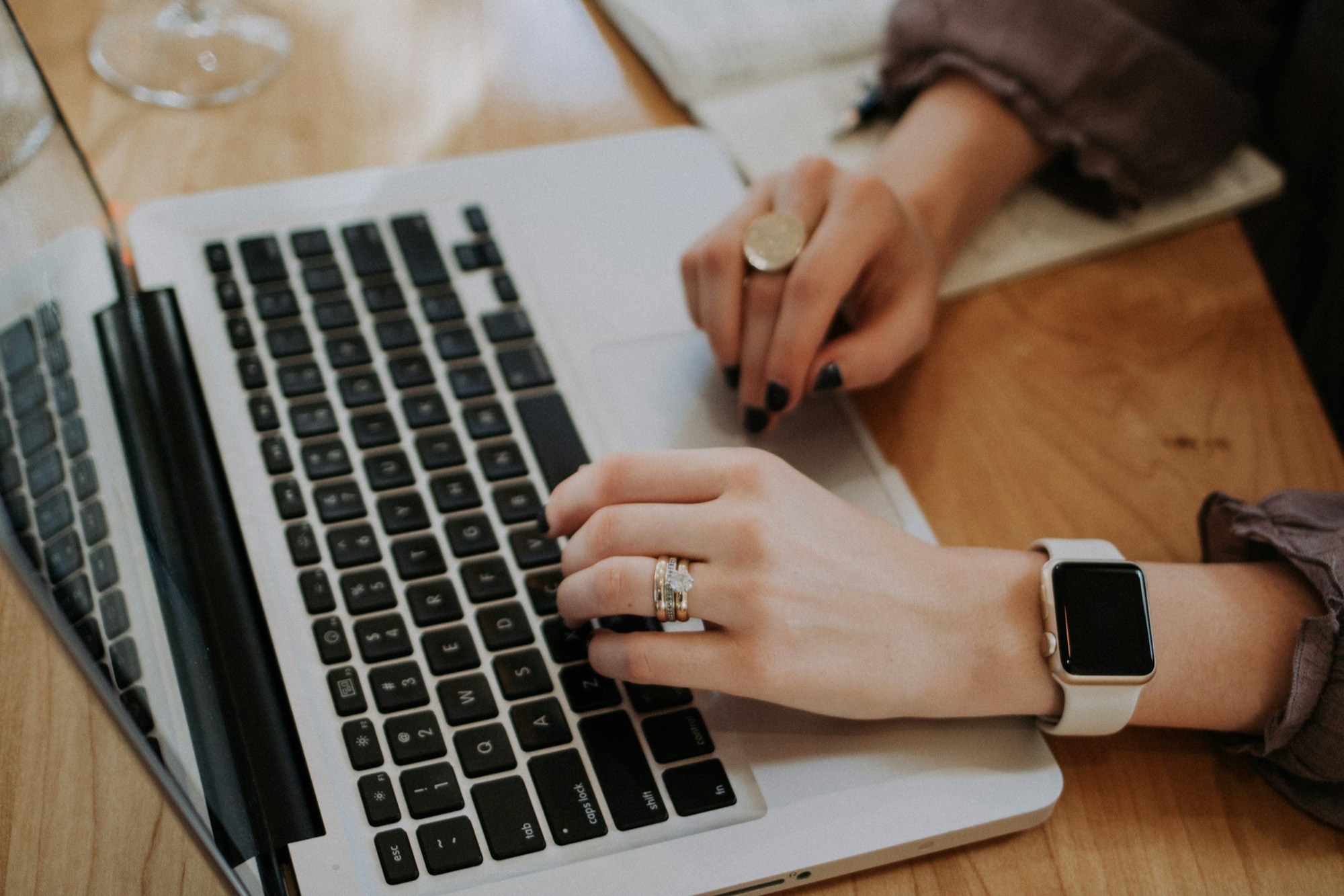 Hands typing on a laptop while managing a short-term rental